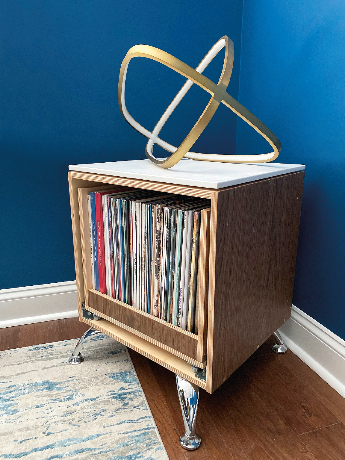 The Chelle Vinyl Cube by Form & Finish, shown here in walnut, comes with a removable storage crate that glides thanks to soft close undermount drawer slides. The cube features integral grommeted cord management and is customizable, 24 x 19 x 20.5 in.