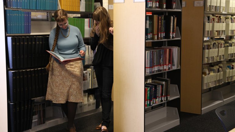 researchers looking at a book at the american craft council library in minneapolis