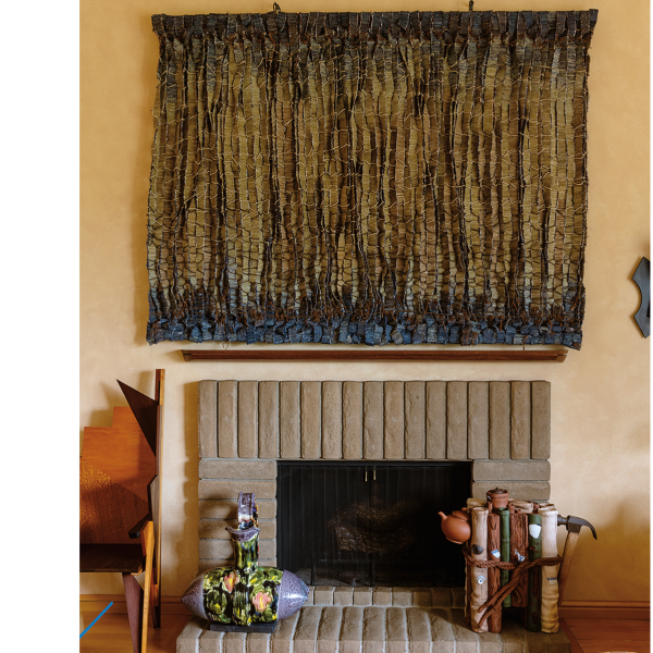 Olga de Amaral’s Riscos I (Fibra y Azul), 1983, woven wool, linen, horsehair, gesso and paint, 65 x 84 x 4 in., hangs above Betty Woodman’s Rose Pillow Pitcher, 1990, glazed earthenware, 23 x 23.25 x 14.5 in. (left) and Xiaoping Luo’s A-1 Teapot, 2004, glazed and painted ceramic, 26 x 33 x 9 in. (right) on the hearth. Side chair by Jay Stanger, 1986, aluminum, bloodwood, curly maple, pearwood, lacewood, pau amarillo, amaranth, wenge, ebony, 51 x 24.75 x 27.25 in.