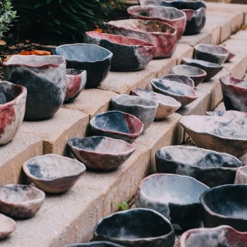 various handshaped earthtoned bowls arranged on brick steps