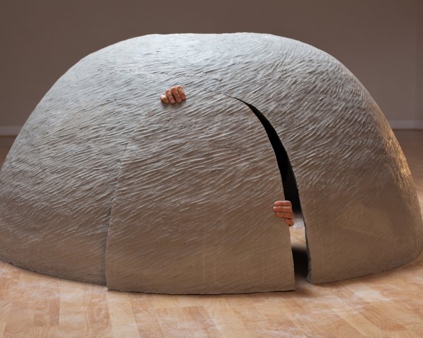 dome shaped ceramic shelter with hands prying open the door from the inside