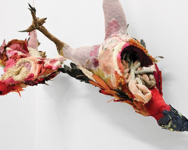multimedia artwork in the style of a mobile featuring two eviscerated chickens hung from one leg
