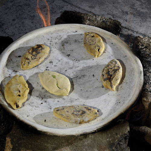 Food cooking on a clay comal