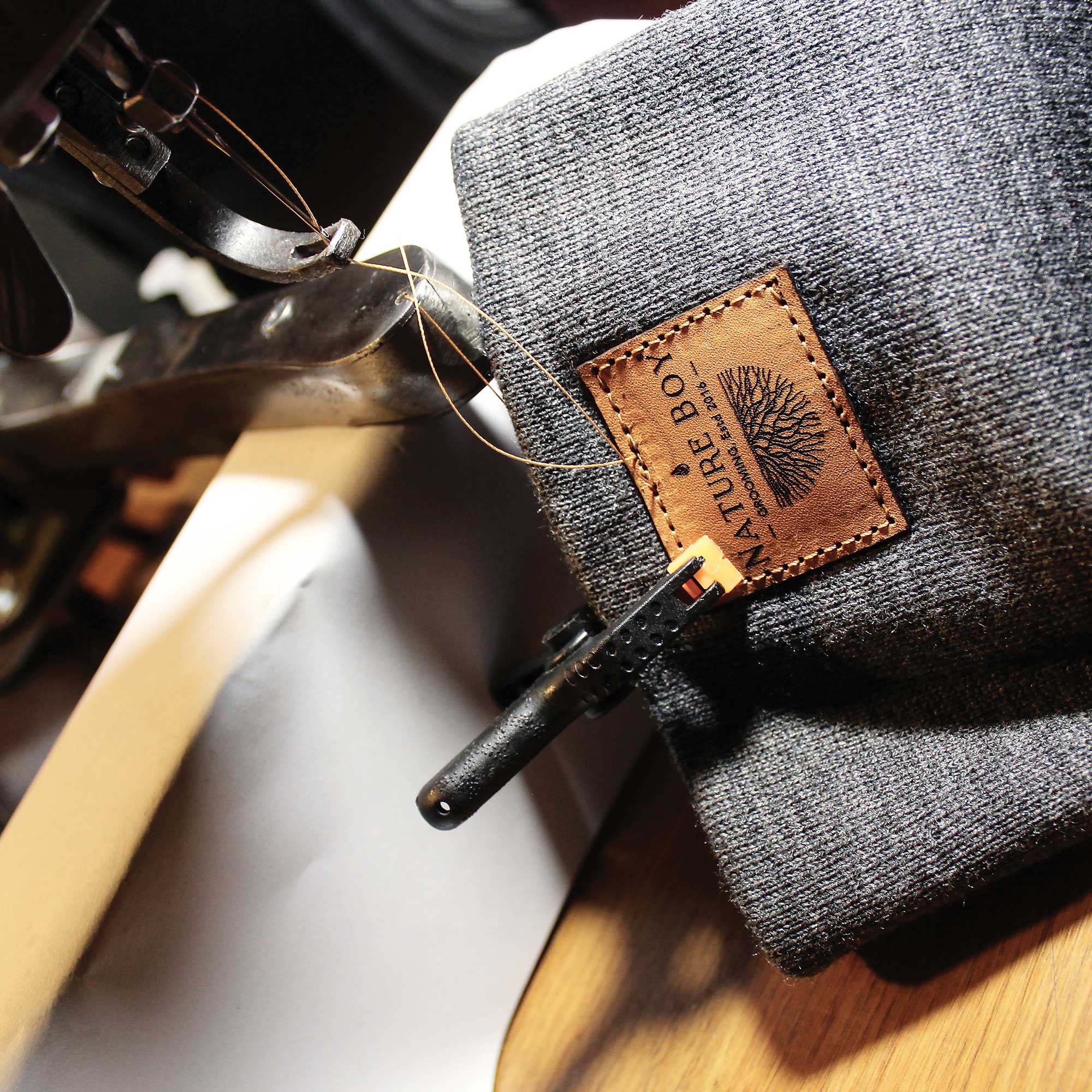 Leather tag being stitched onto a Nature Boy beanie