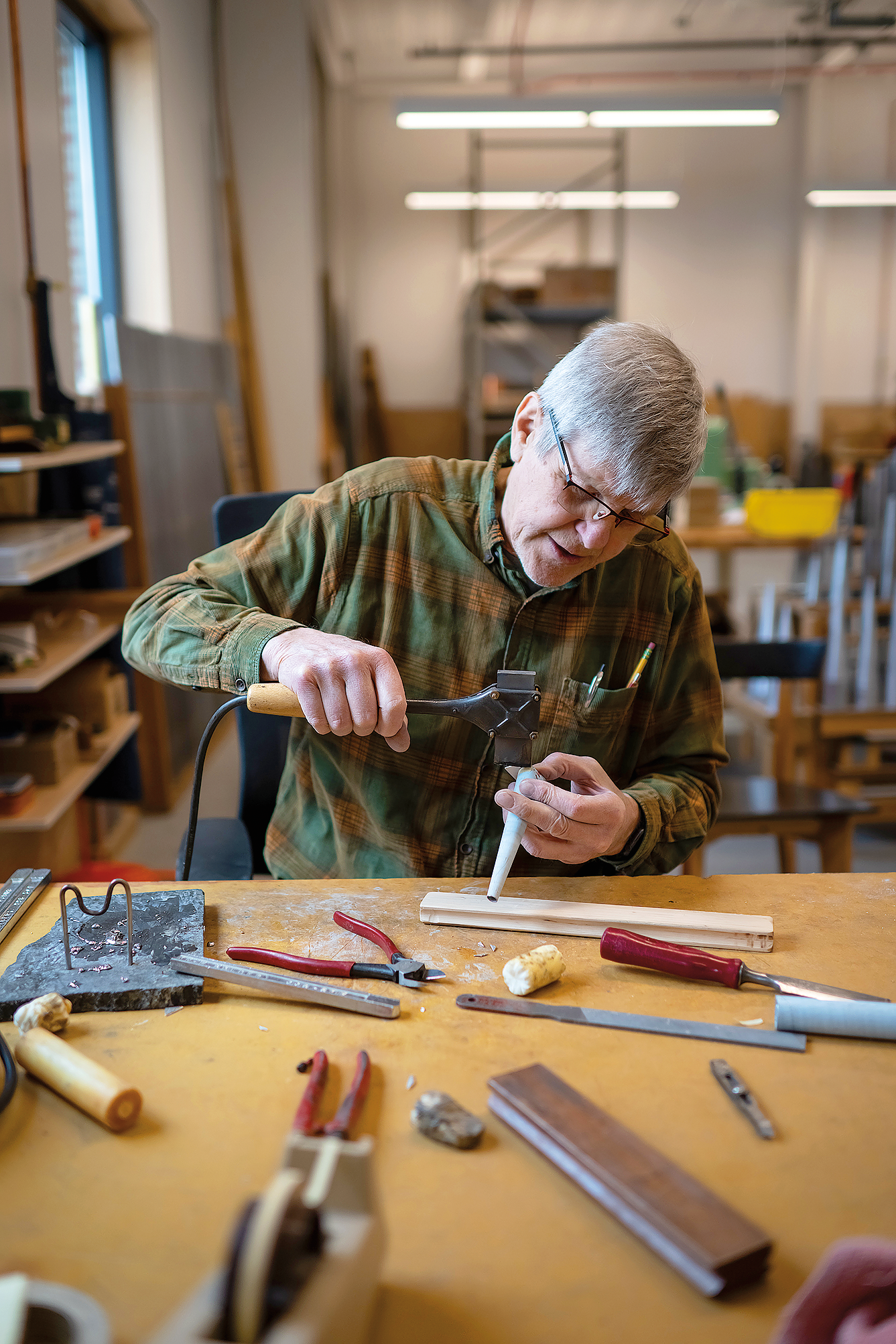 Renowned organ builder Martin Pasi, who moved his shop from Washington state, solders a lead-tin alloy organ pipe. Photo by Caroline Yang.
