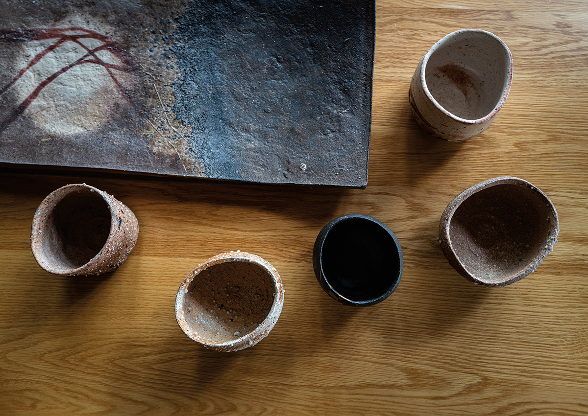 A platter made in Bizen, Japan, and five tea bowls by Tsujimura: three Shigaraki, one Raku with kintsugi repair (third from left), and one Shino (top right).