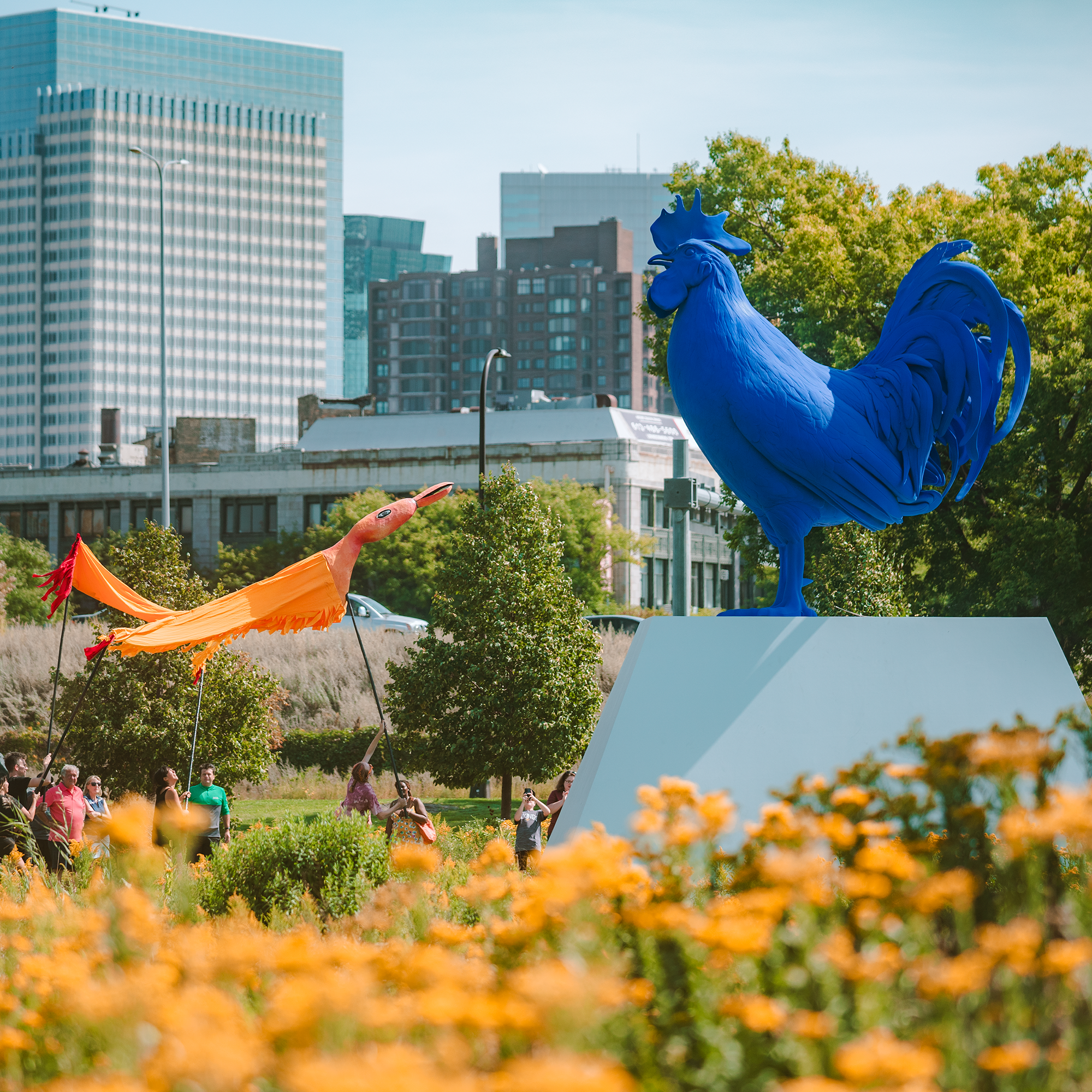 The Minneapolis Sculpture Garden at the Walker Art Center draws patrons during a fall event. Katharina Fritsch’s large fiberglass and polyester resin rooster, Hahn/Cock, is visible on the right. Photo by Kameron Herndon, courtesy of the Walker Art Center, Minneapolis.