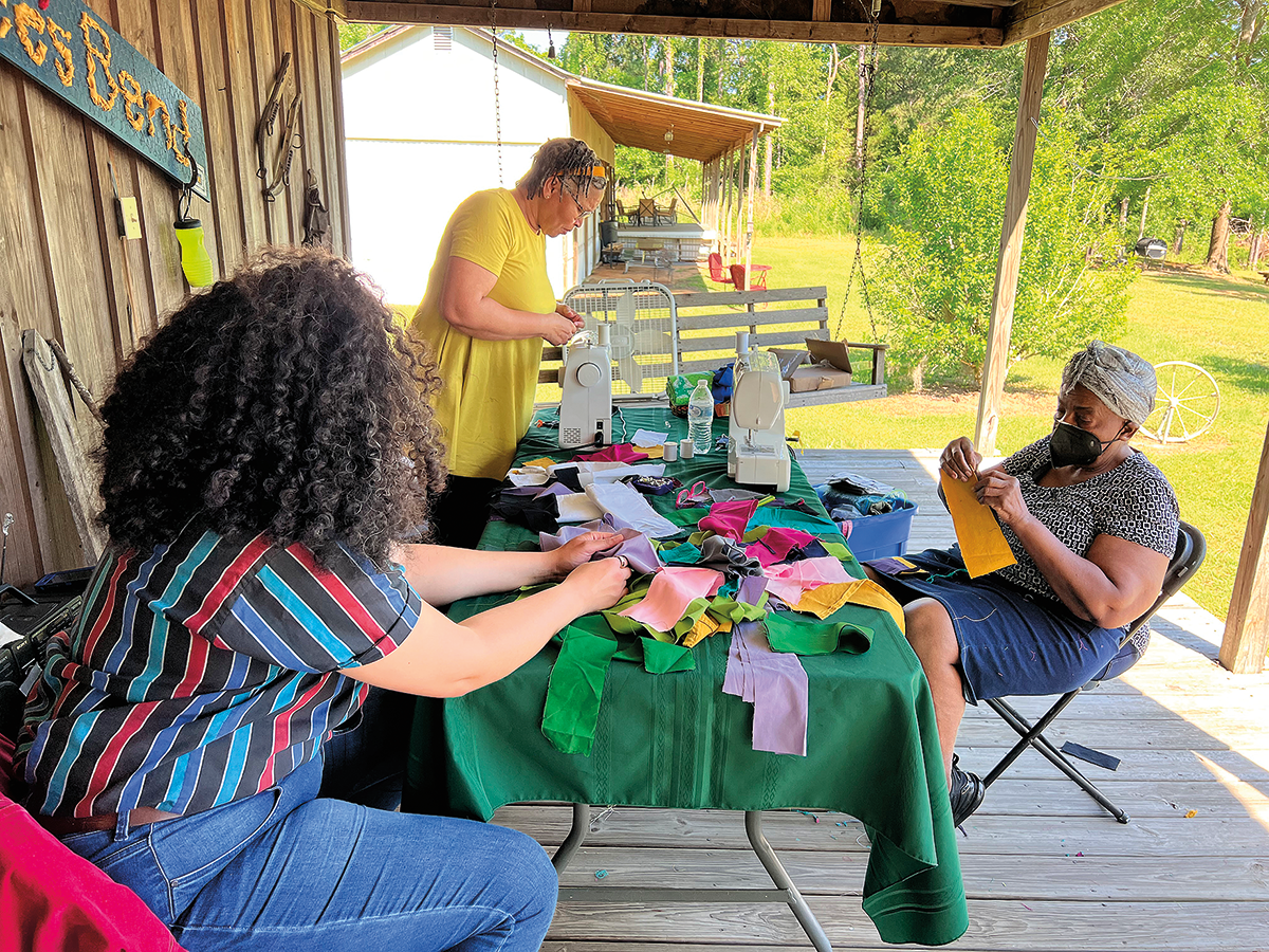 Halcyon Person (left) learns quilting skills from Loretta Pettway Bennett (middle) and Marlene Bennett Jones (right). 