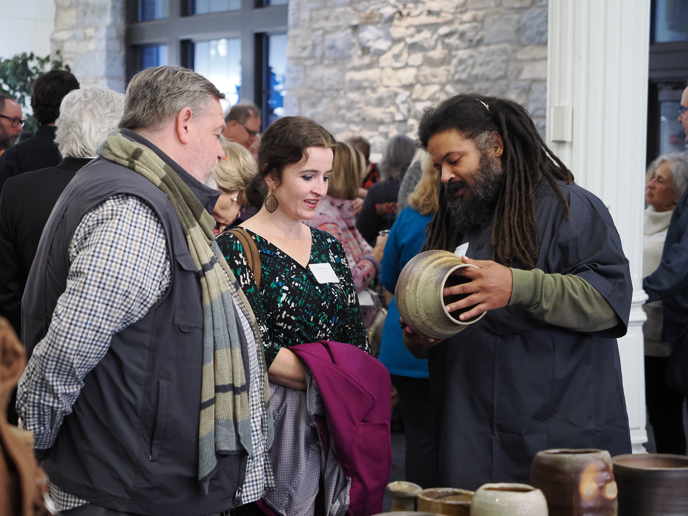 Artist Dom Venzant showing guests a cermic vessel