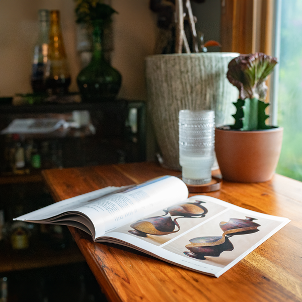 an issue of American Craft magazine on a wooden table by a window