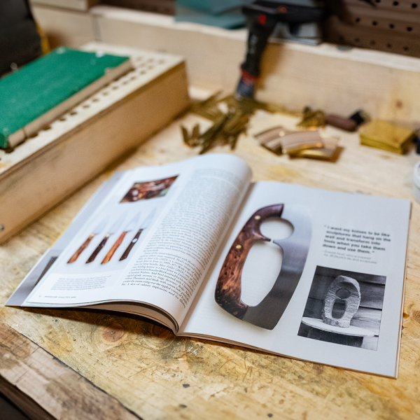 Issue of American Craft magazine spread across a carpenter's workbench.