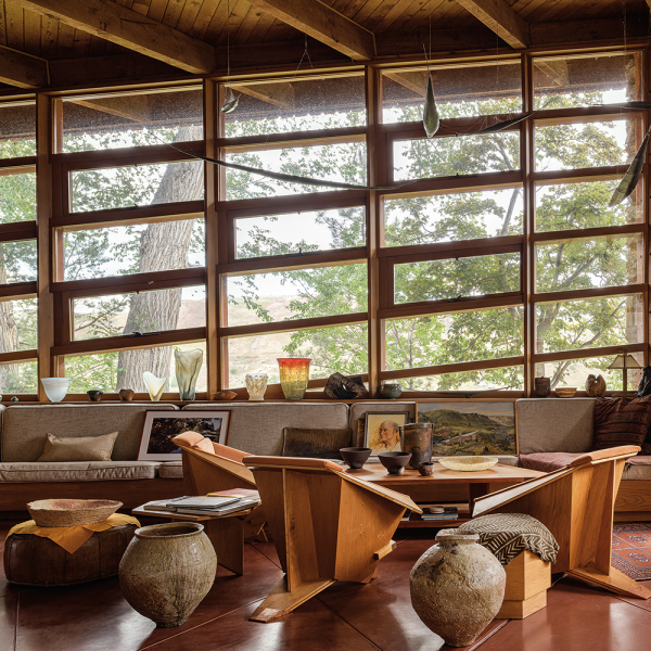 Wright designed the Origami Chairs in 1949, and Whiting had them made in 1984 from plans left in the studio. Shiro Tsujimura made the large bowl on top of the left ottoman in 2023, as well as the two vessels sitting on the floor. On the table are two medium-sized bowls by Richard DeVore. A landscape painted by Archie Teater rests on the couch. 