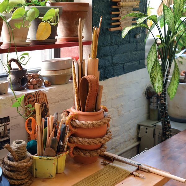 A pot holds tools for backstrap weaving. Dyed silk warp is laid out for an in-progress piece. Photo by Terumi Saito. 