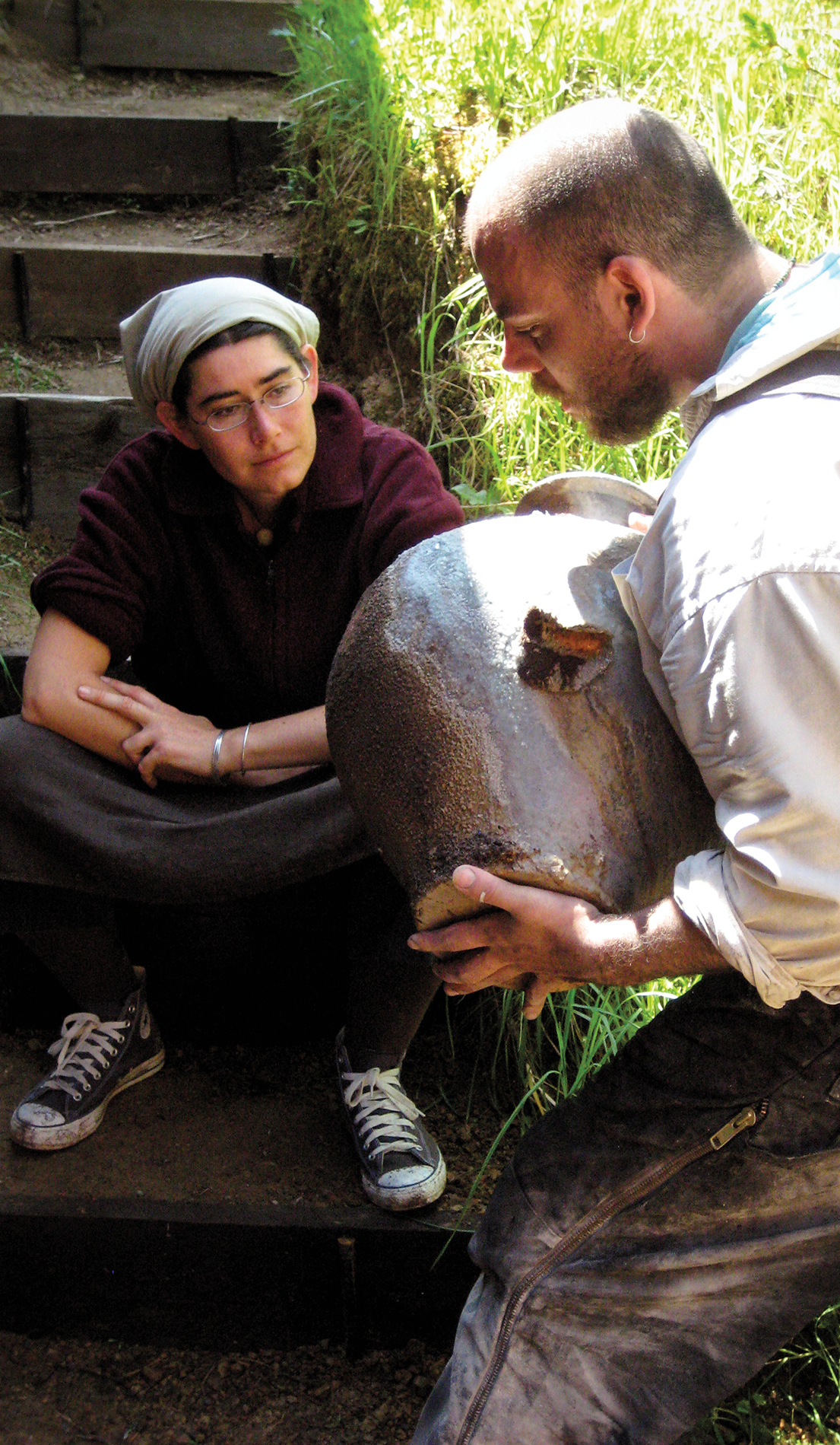 Anandamayi Arnold and Nick Schwartz looking at a new pot from the anagama kiln.