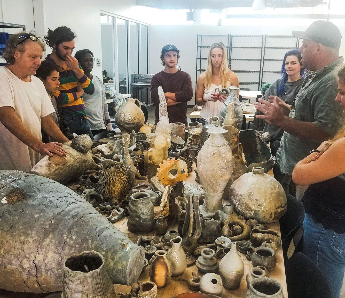 Students look at their ceramic work after it's removed from the kiln.