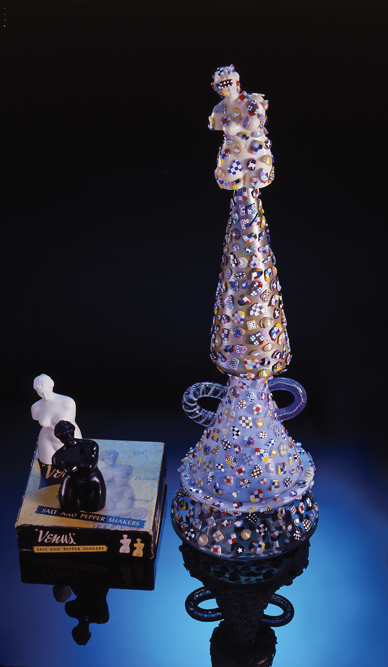 Blown glass sculpture decorated with found objects and bits of murrine glass