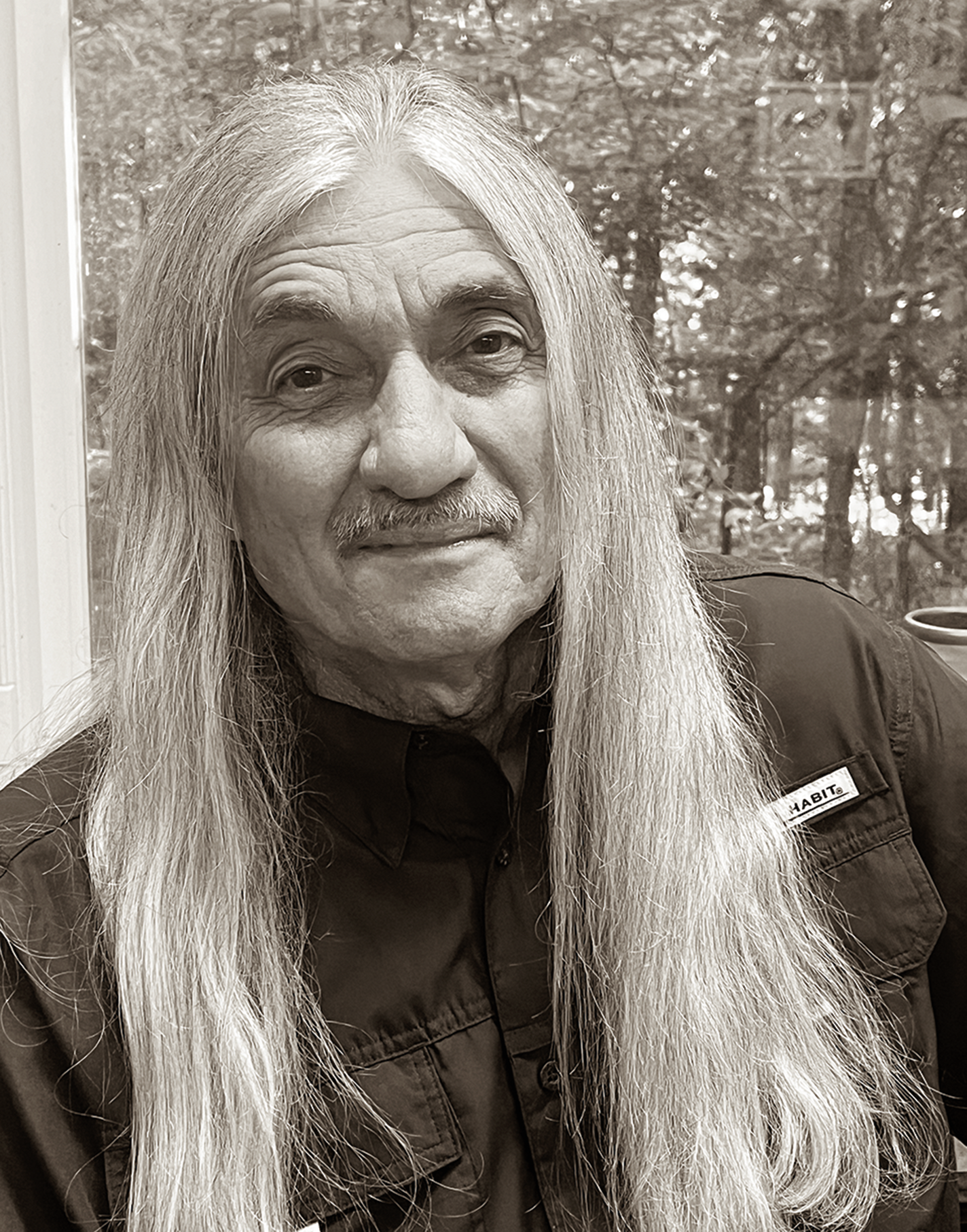 Portrait of Bill Harris, who has long gray hair and a moustache.