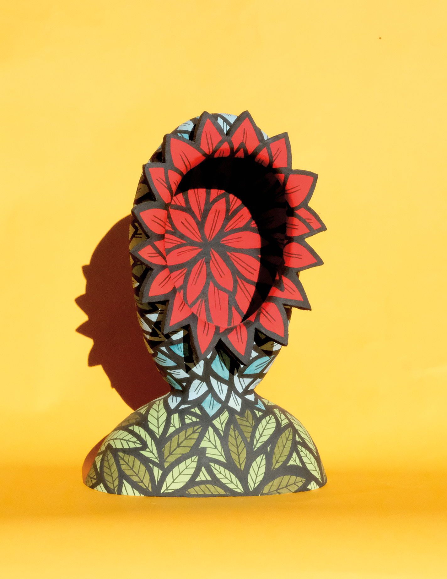 Bust-like sculpture with a red dahlia face