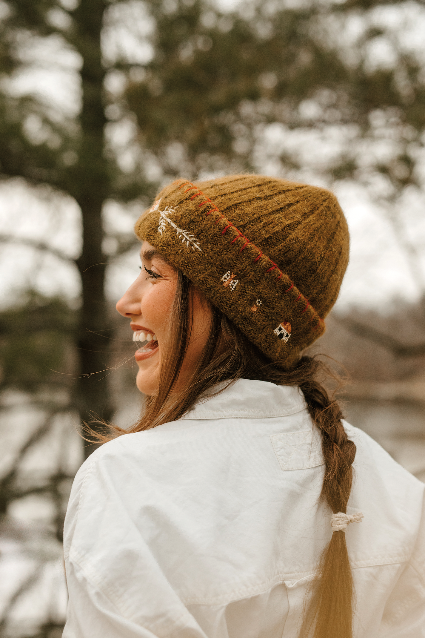 Model wearing alpaca beanie with embroidery and beadwork.