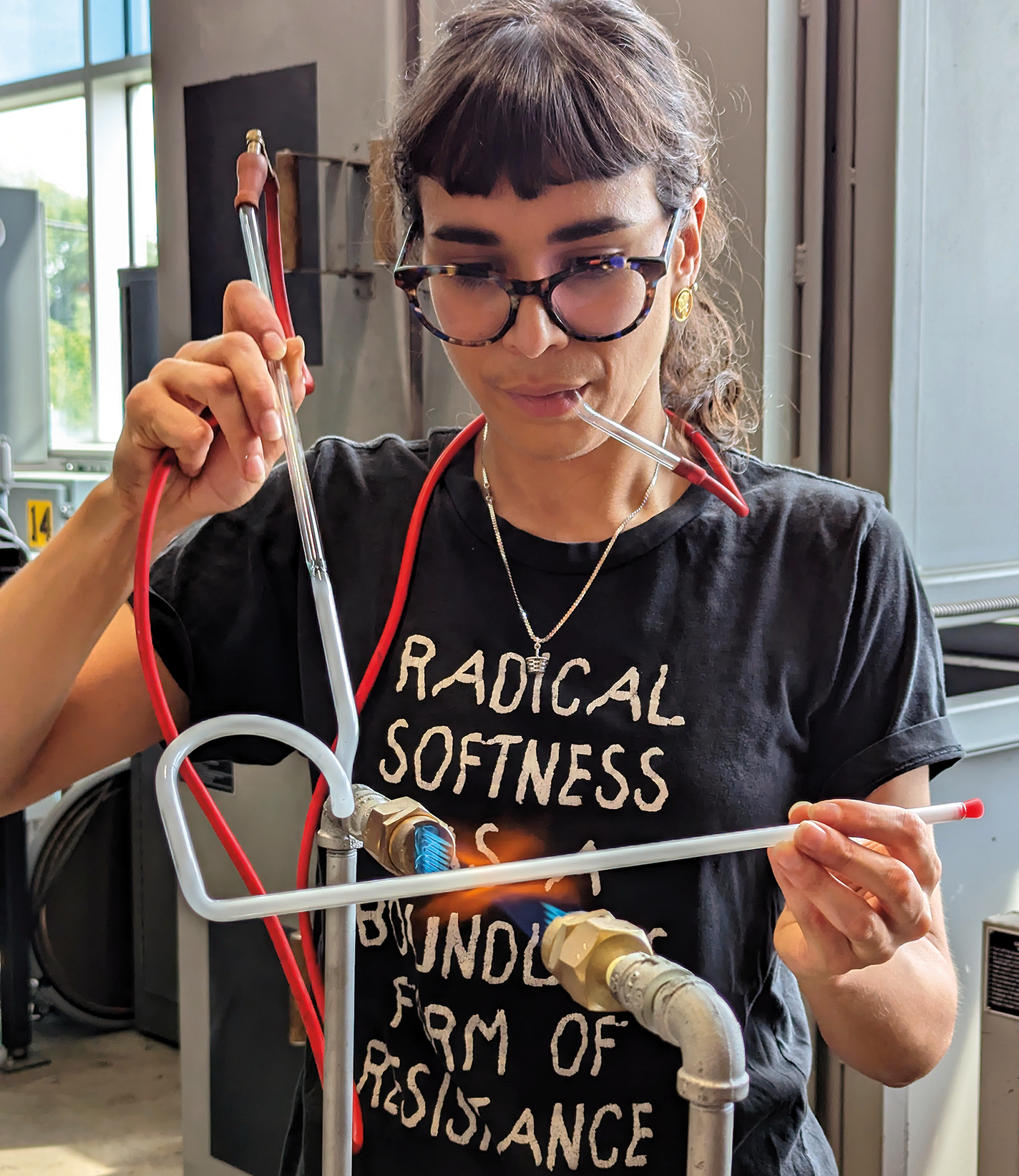 Victoria Ahmadizadeh Melendez bends a glass tube for a neon artwork