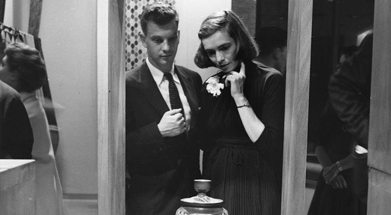 Two people looking at a ceramic vessel