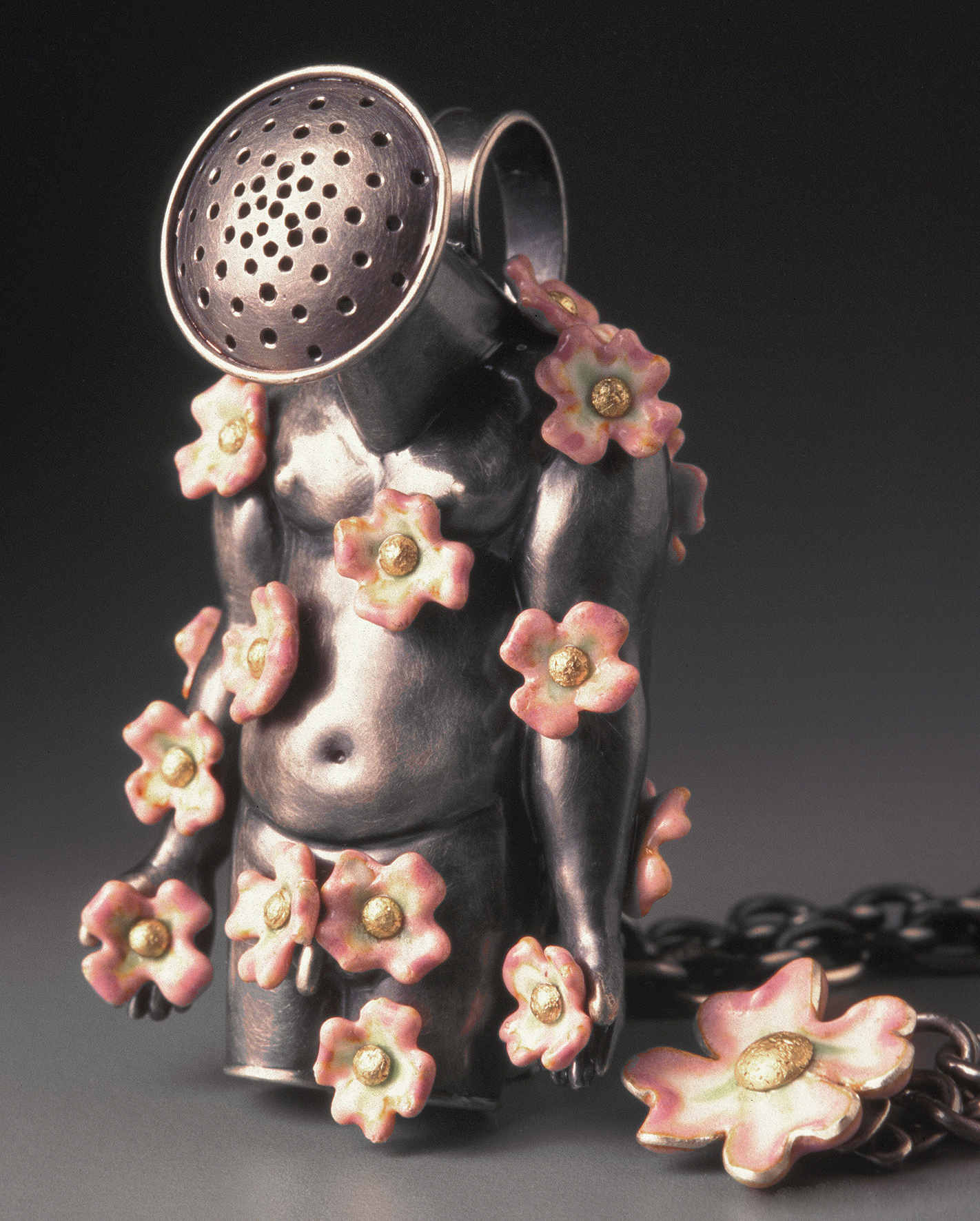 Pendant made of fine metals and diamond depicting a male torso covered in flowers with a loudspeaker for a head