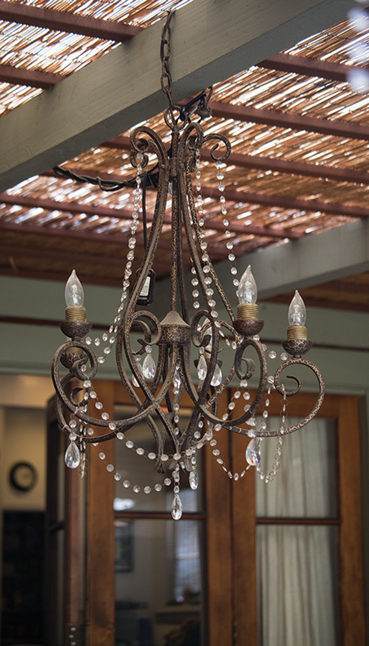 A chandelier hangs from a bamboo ceiling
