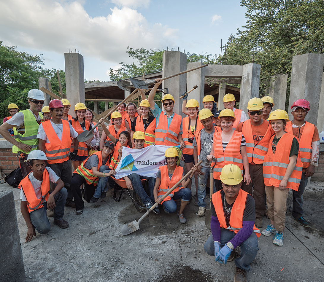 Collins with a group of volunteers in hard hats and safety vests