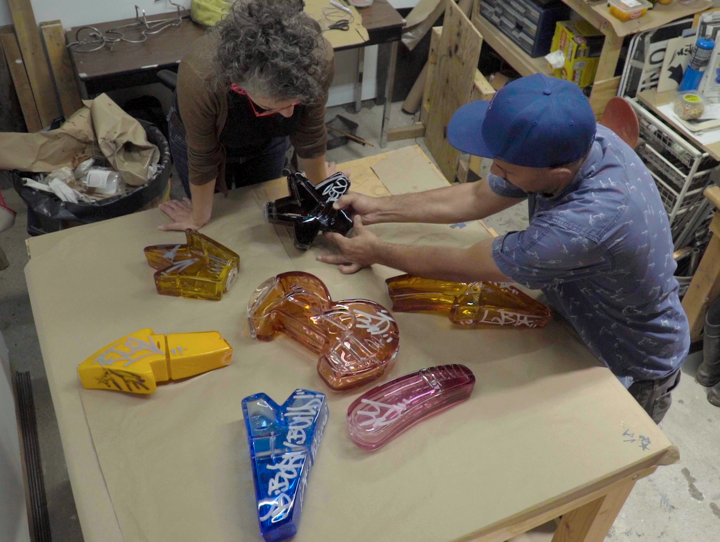 The artist in his studio working on blown-glass graffiti forms.