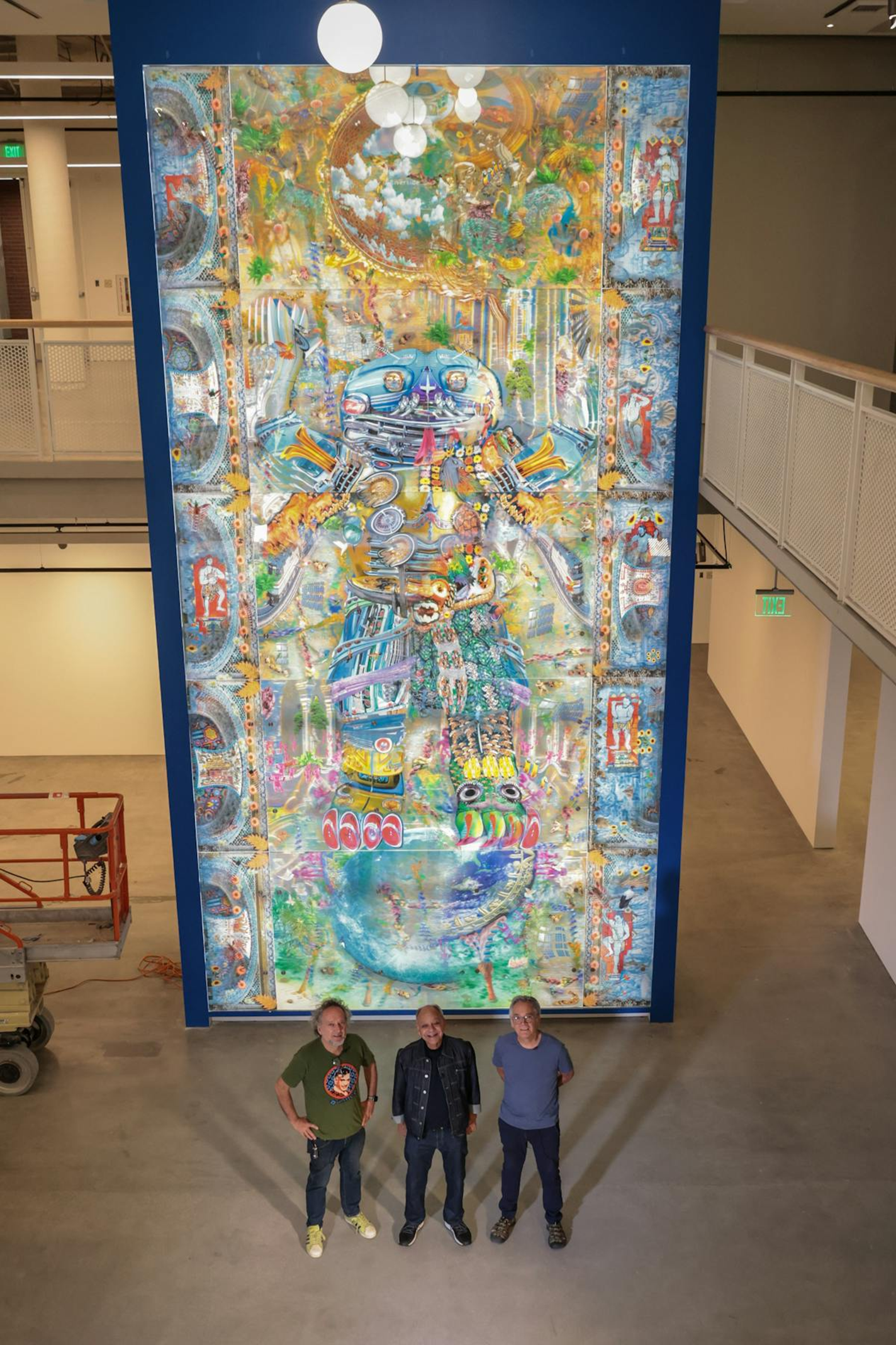 Cheech Marin, Einar de la Torre, and Jamex de la Torre stand in front of the de la Torre Brothers' 26-foot-tall lenticular artwork.