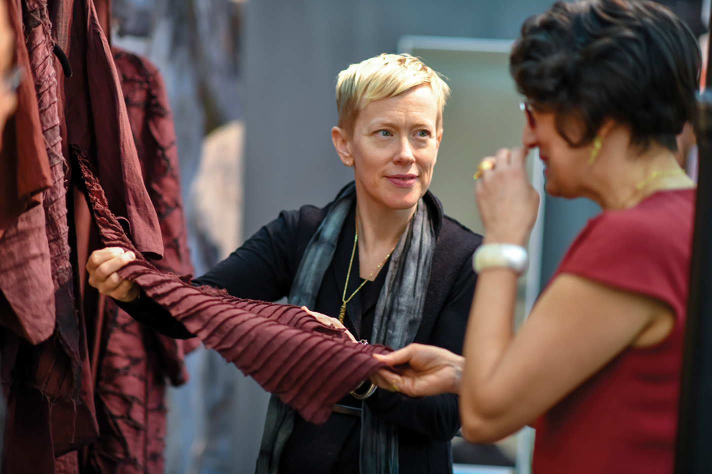 Show attendees examine a piece of textile art.