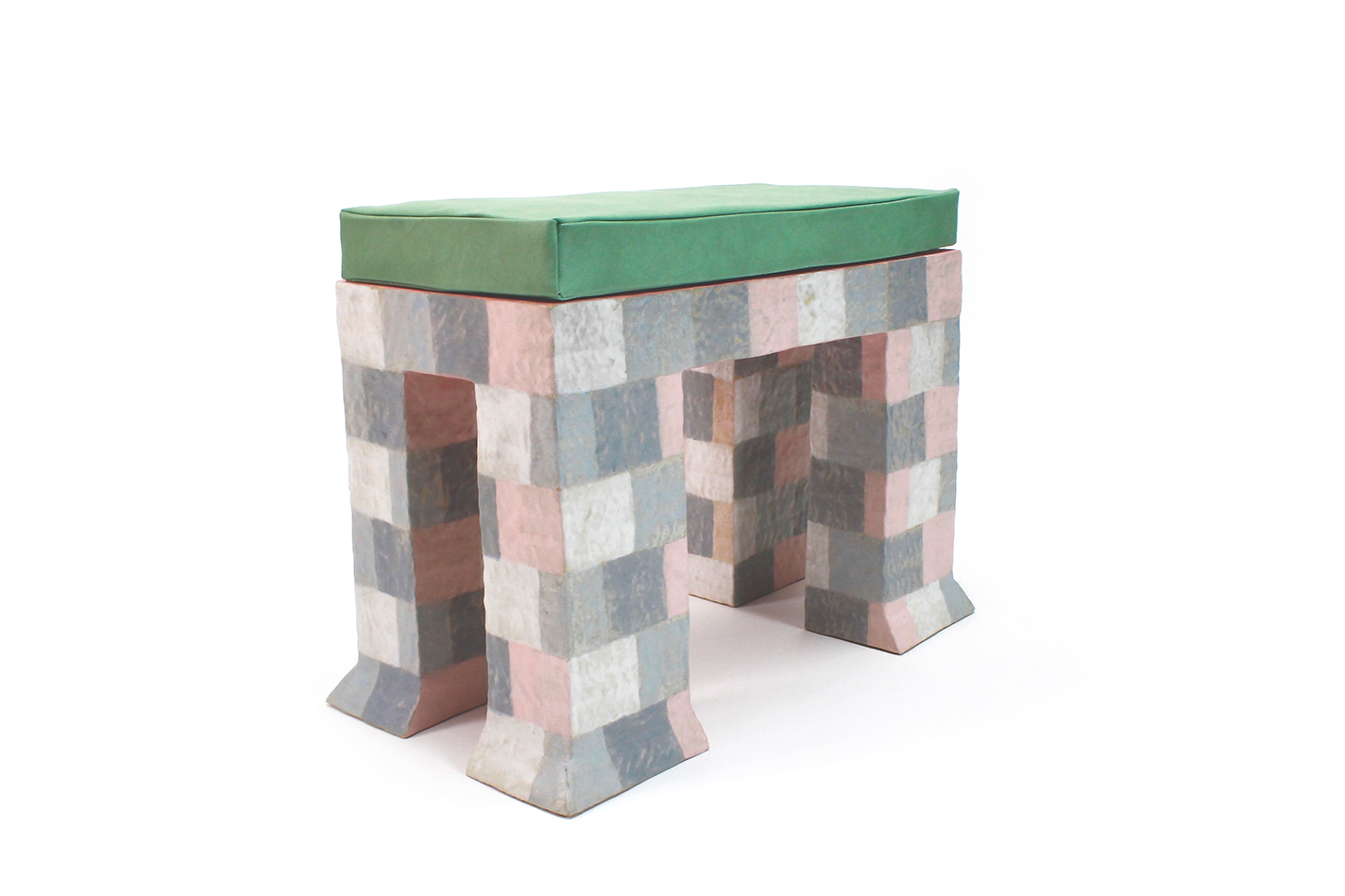 Ceramic bench with a pink and gray checked pattern, flared legs, and a green bench cushion.
