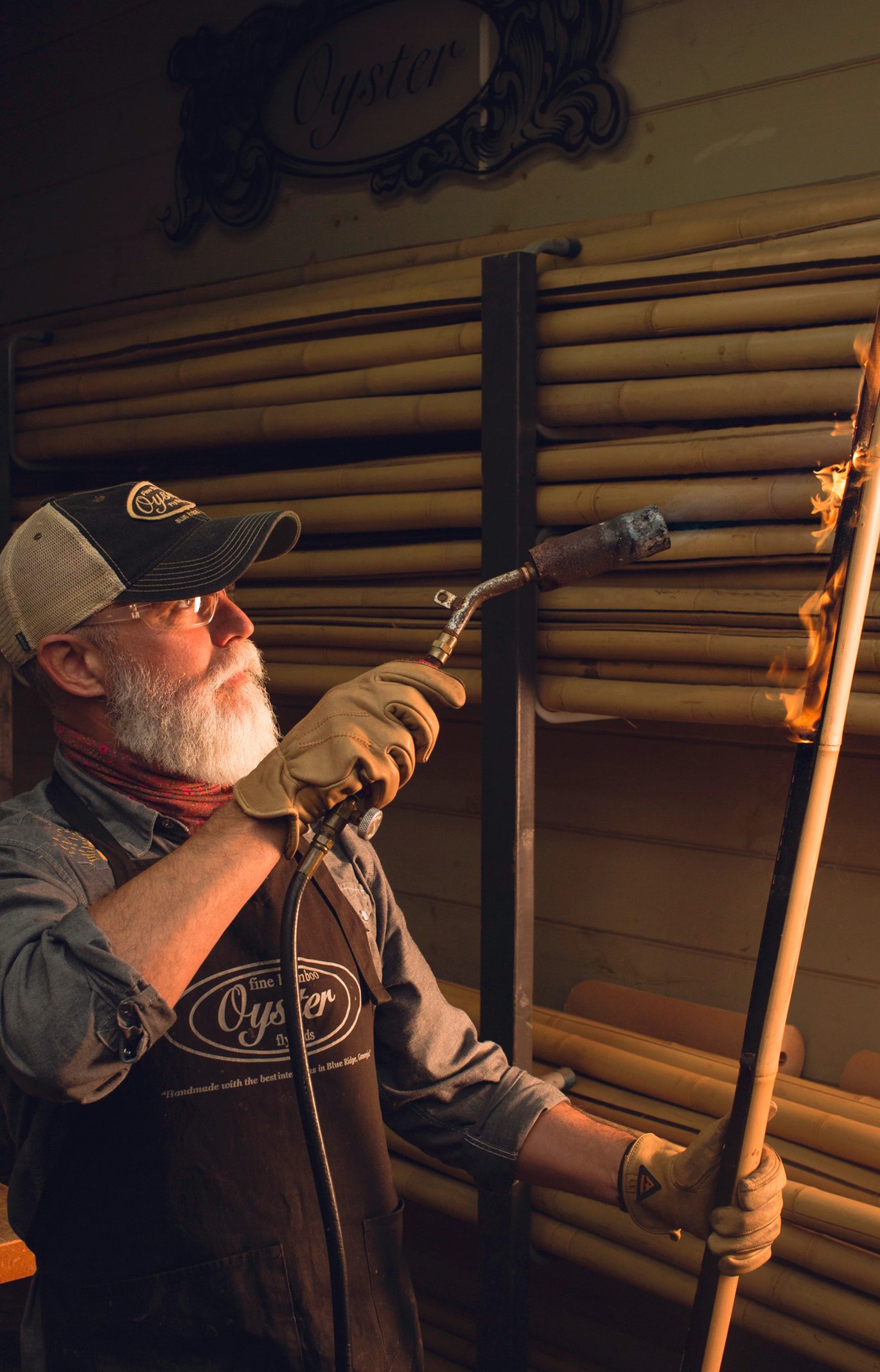 Bill Oyster uses a blowtorch on a culm of bamboo.