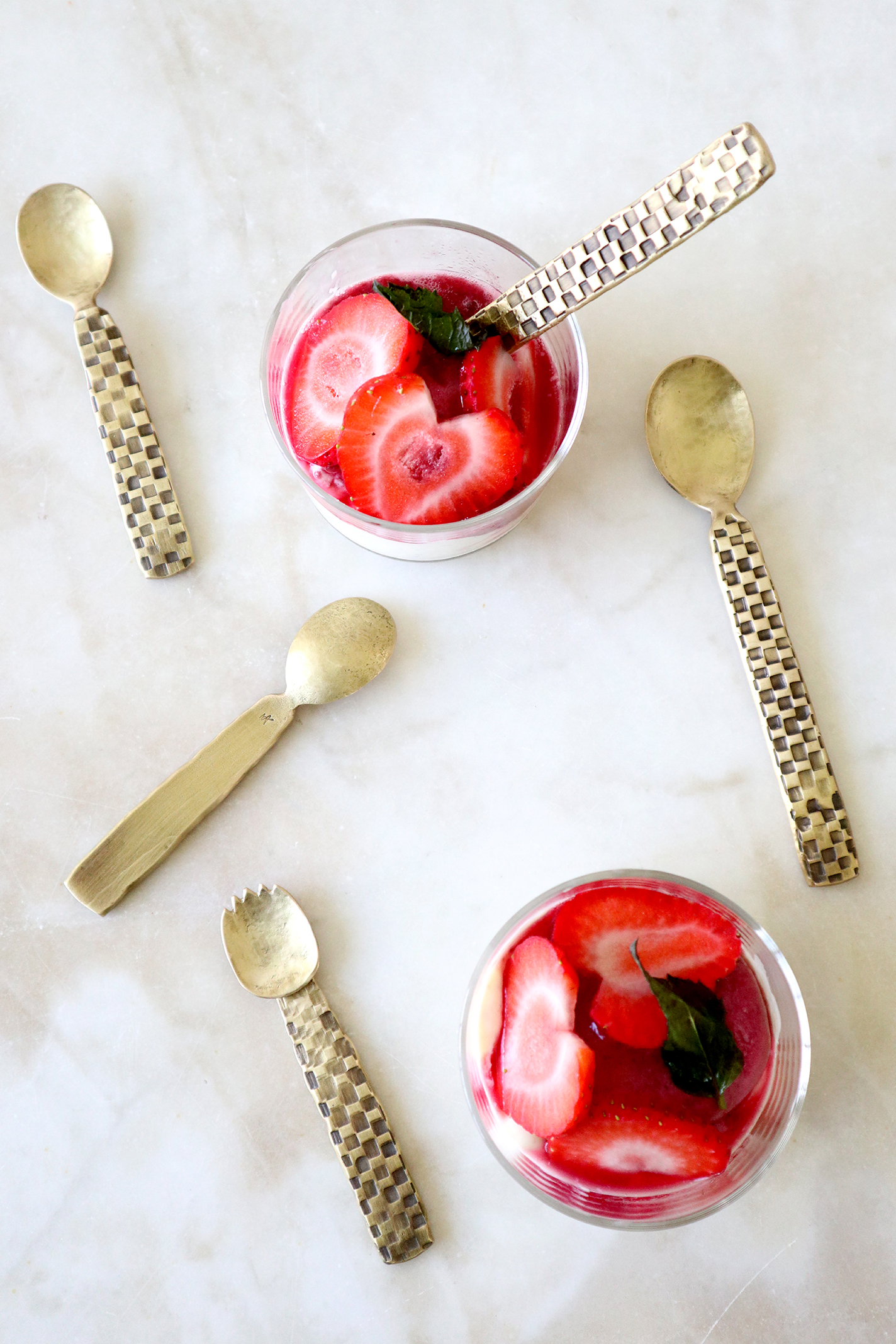 Small forged brass spoons with check-patterned handles.