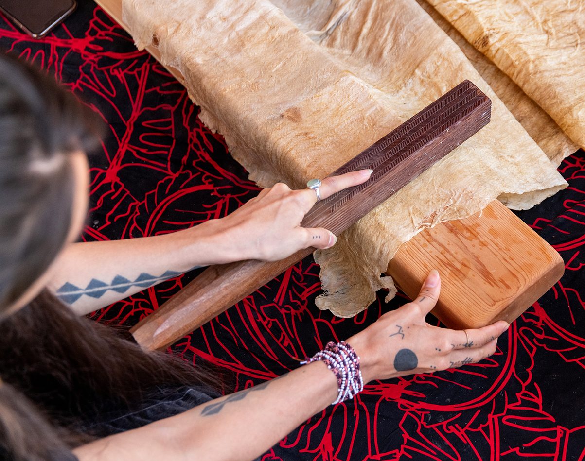 Lehuauakea works on a large piece of kapa.