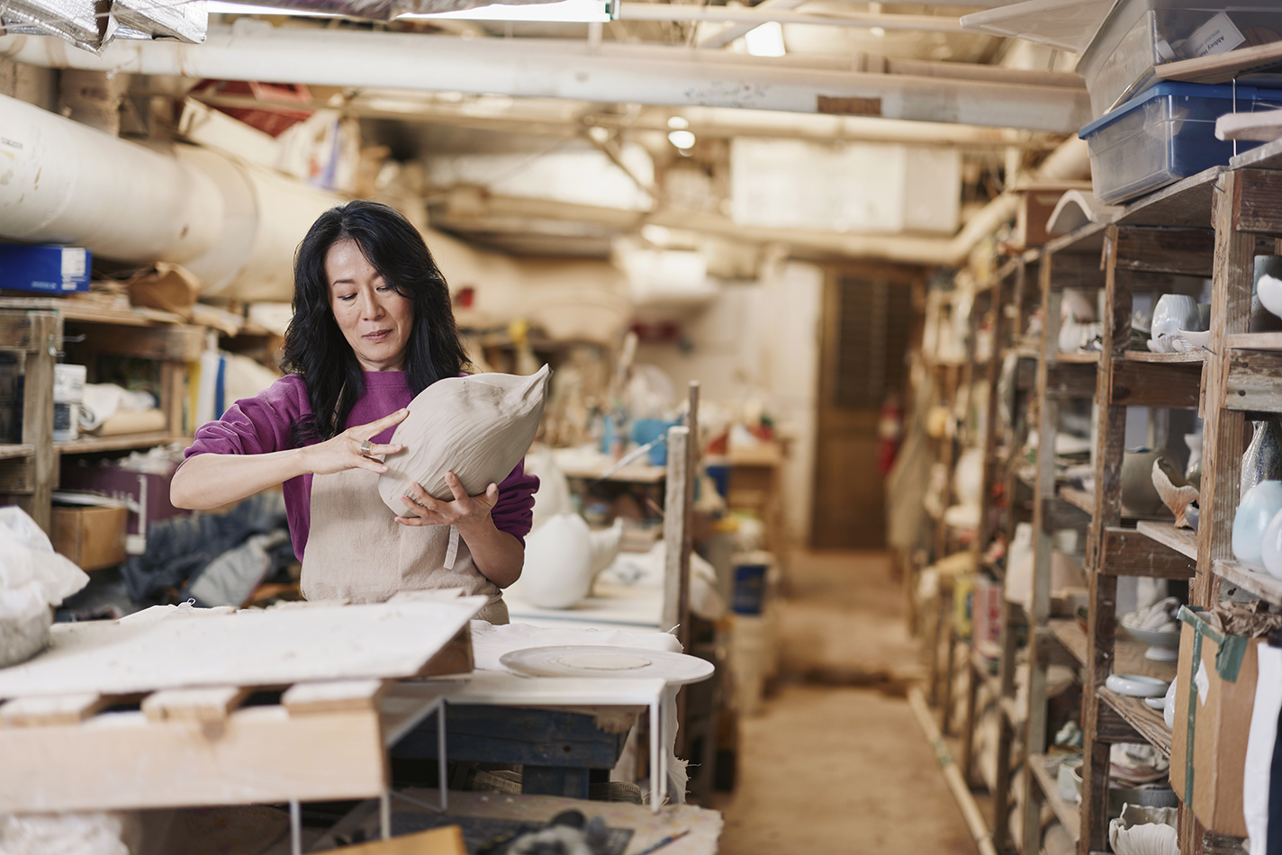 Kate Pak in her studio, holding an in-progress vessel.