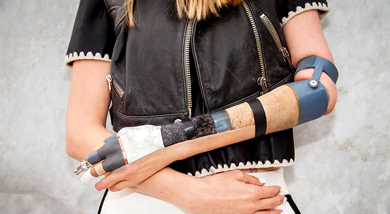 Kelly Knox wears a prosthetic arm made with silicone and interchangeable steel, rock, earth, wood, moss, oil, cork, wool, bronze, rhodium, and gold parts.