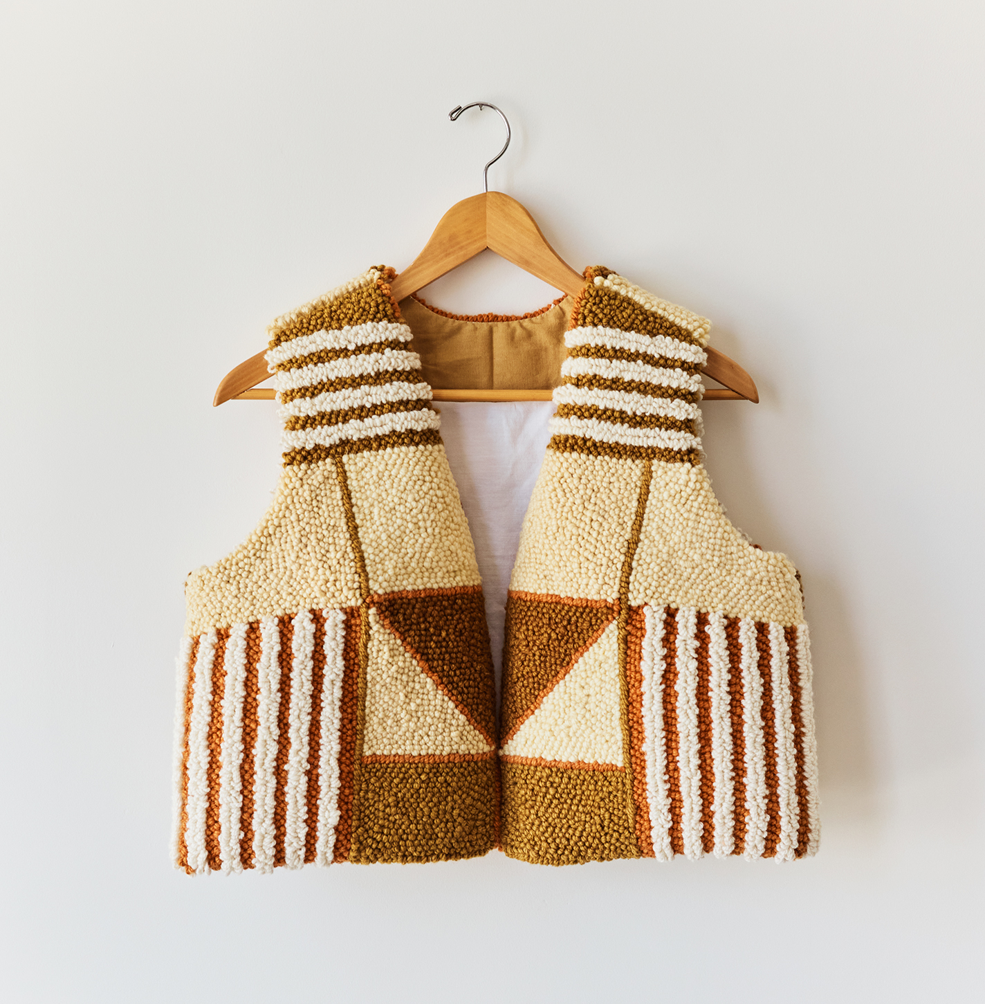 A color-blocked punch needle vest in brown and cream.