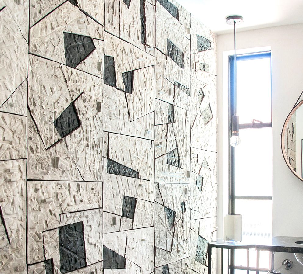 Textured ceramic mural on bathroom wall.