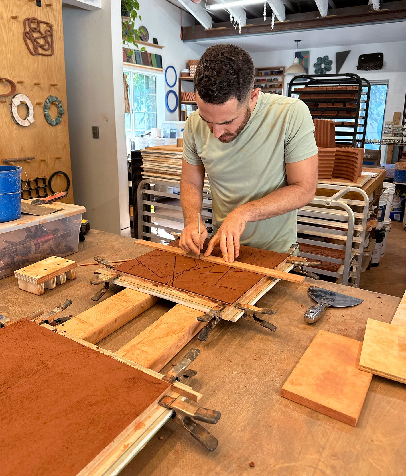 Medansky sculpts terra-cotta tiles in his studio.