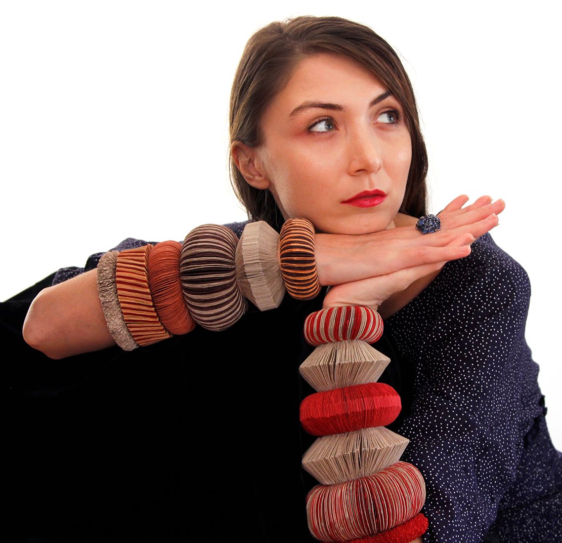 A model wears a collection of paper bracelets.