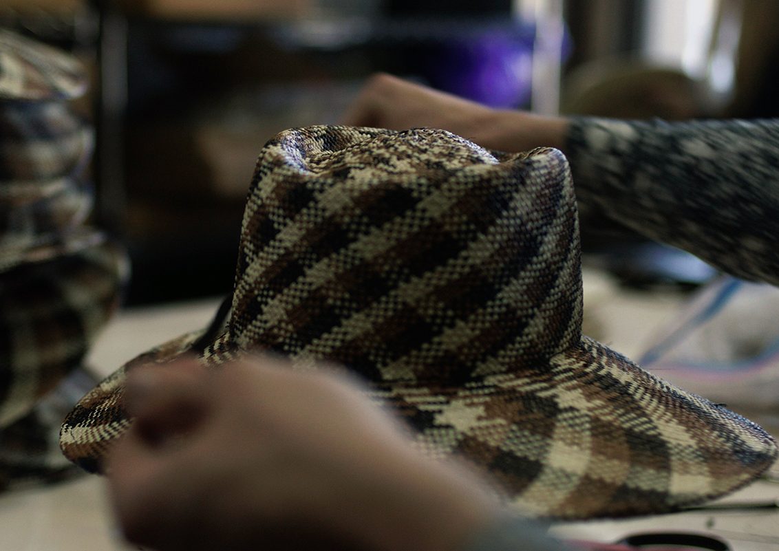 Handcrafted hats being trimmed