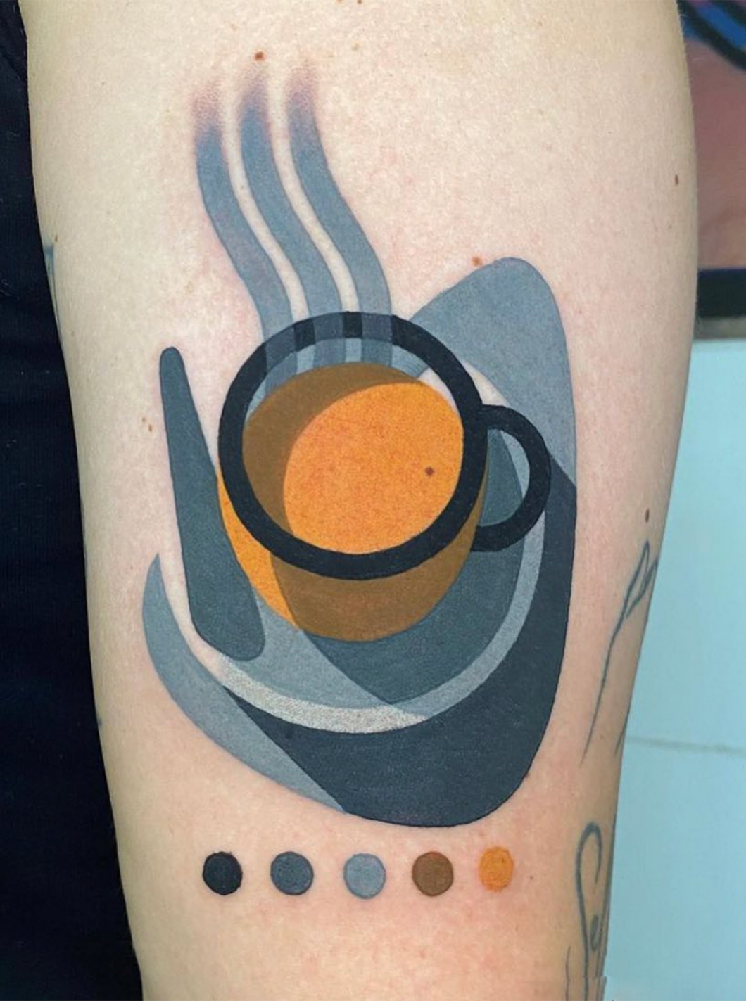 Tattoo of coffee cup with steam rising off it