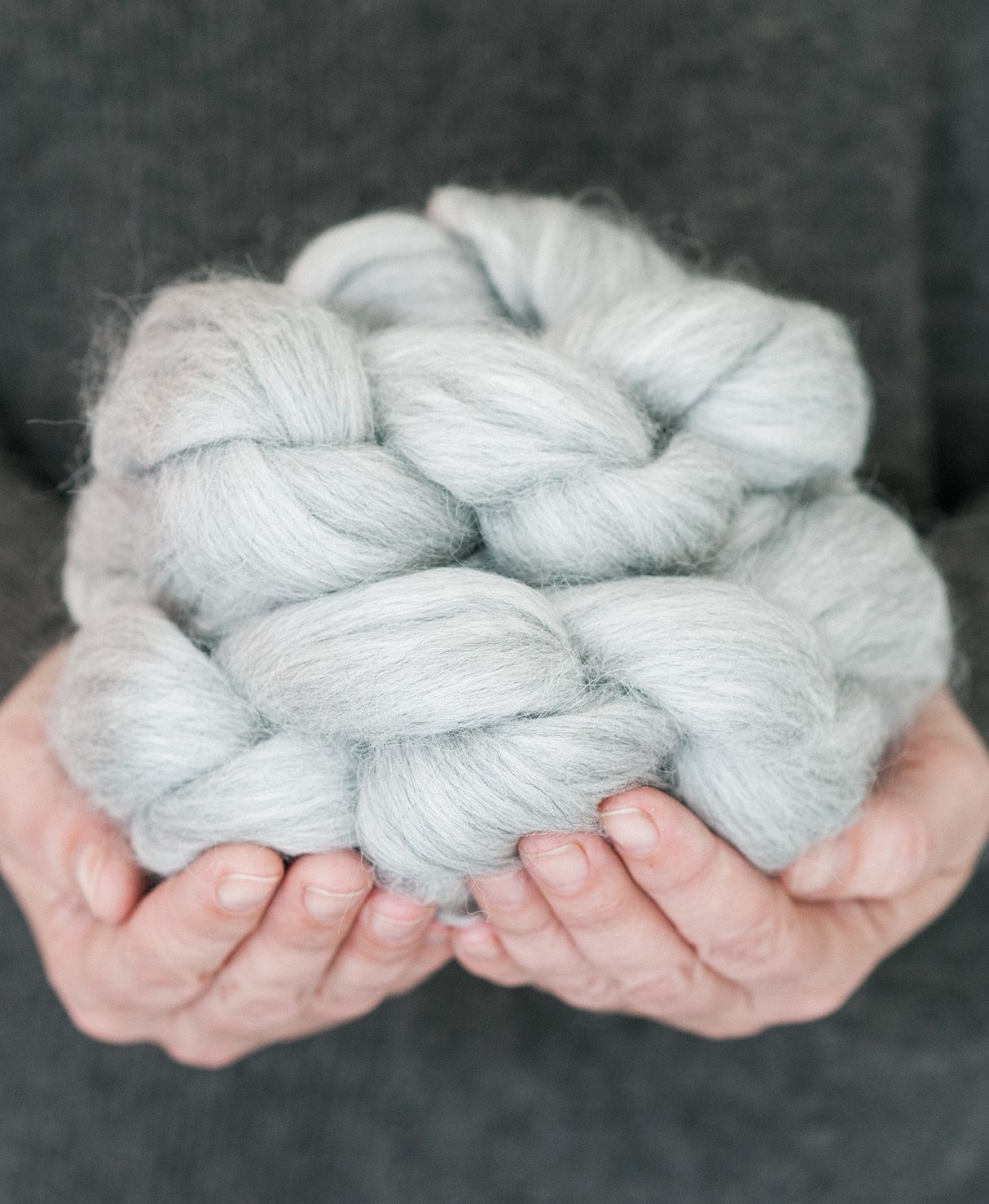 Colombano holds a skein of wool.