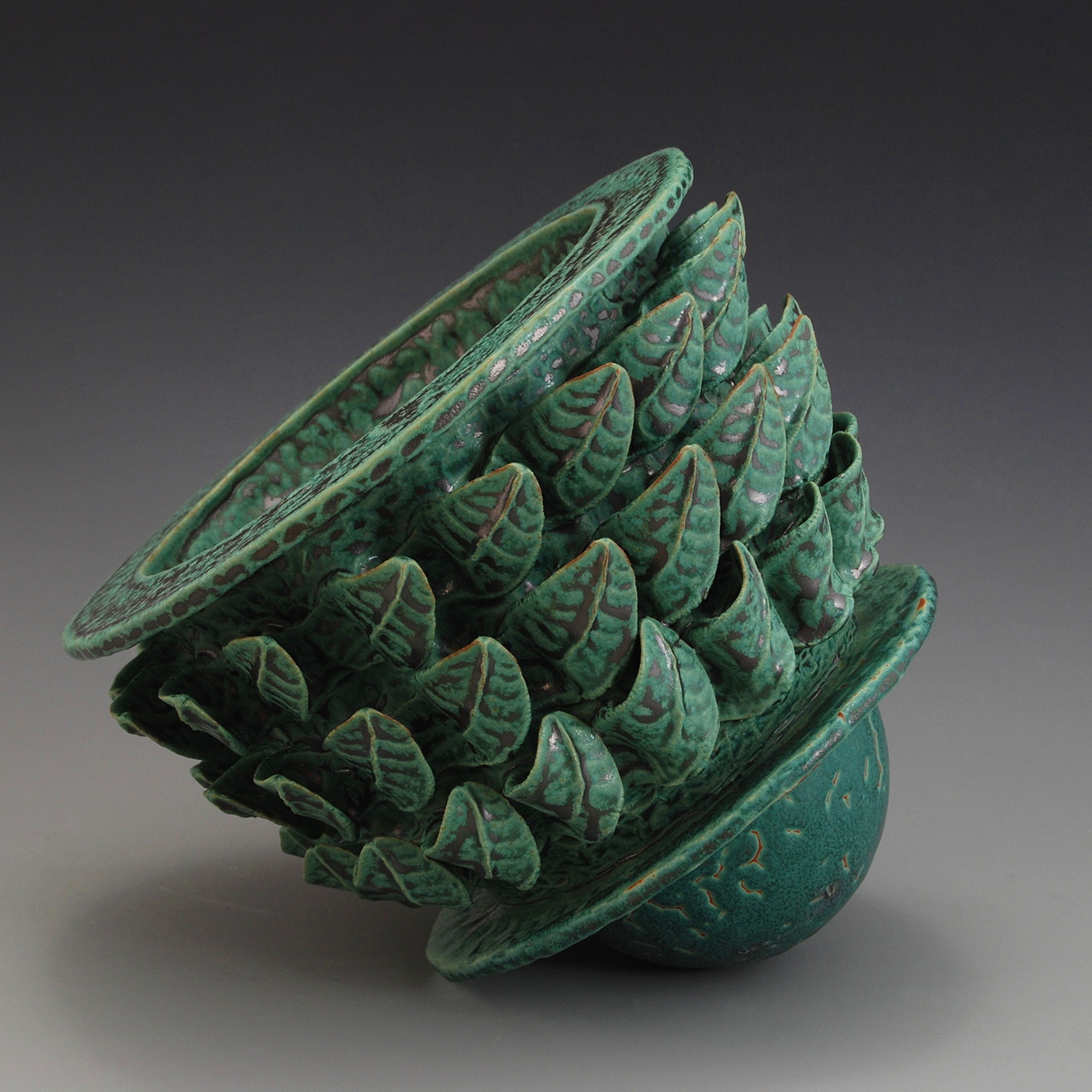 Pinch-formed vessel with leaf shapes and green glaze