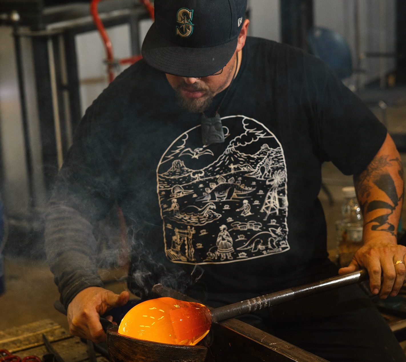 Friday uses a cherrywood block to shape glass in a hot shop.