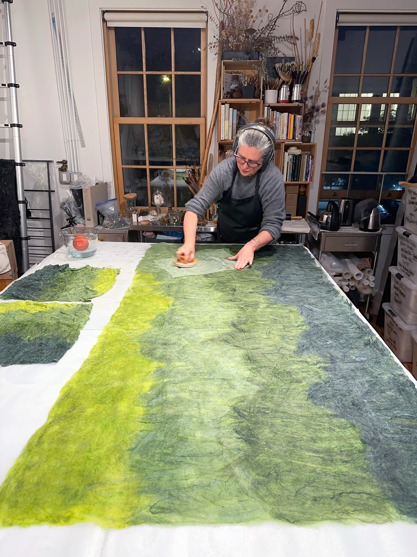 Working on a custom ombré felt, Colombano rubs the wet surface with a waffle-patterned tool to encourage the fibers to bond.