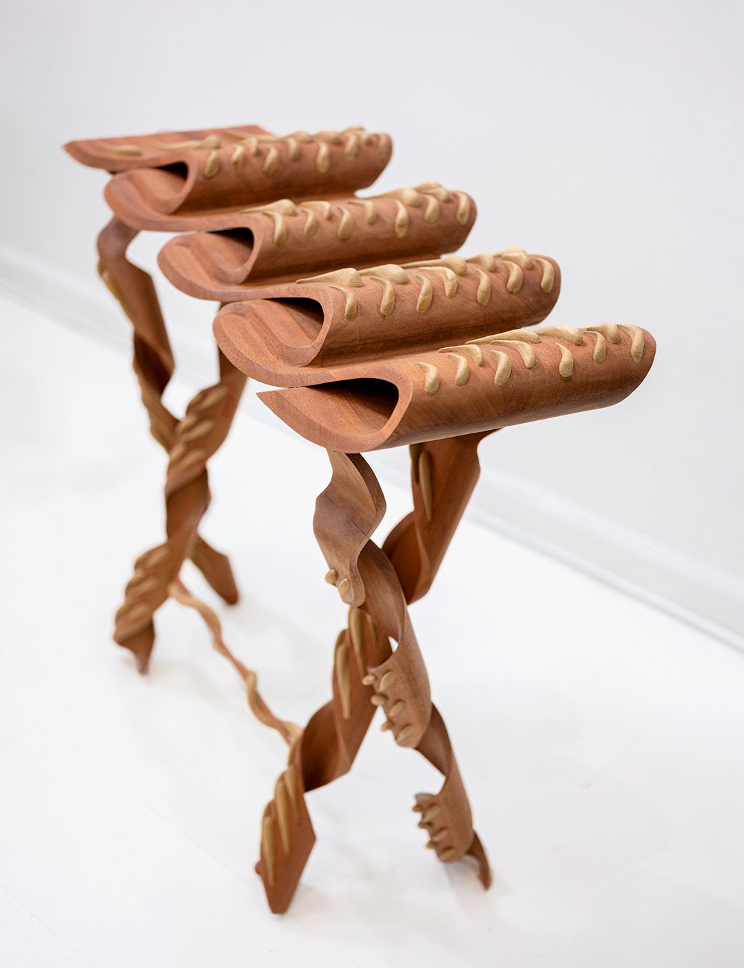 Sapele and poplar table with elaborate folds and curves