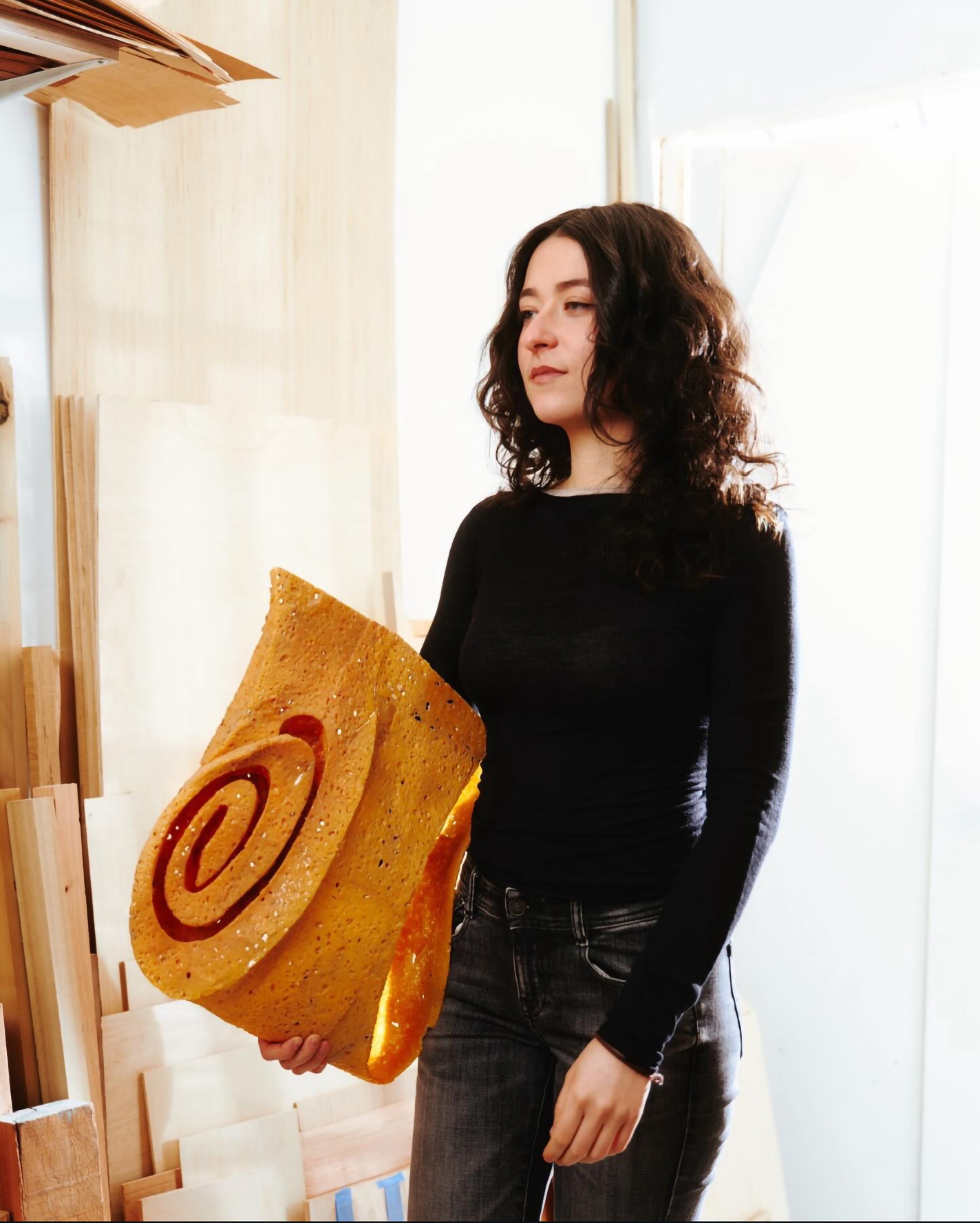 Portrait of the artist holding a piece of her work.