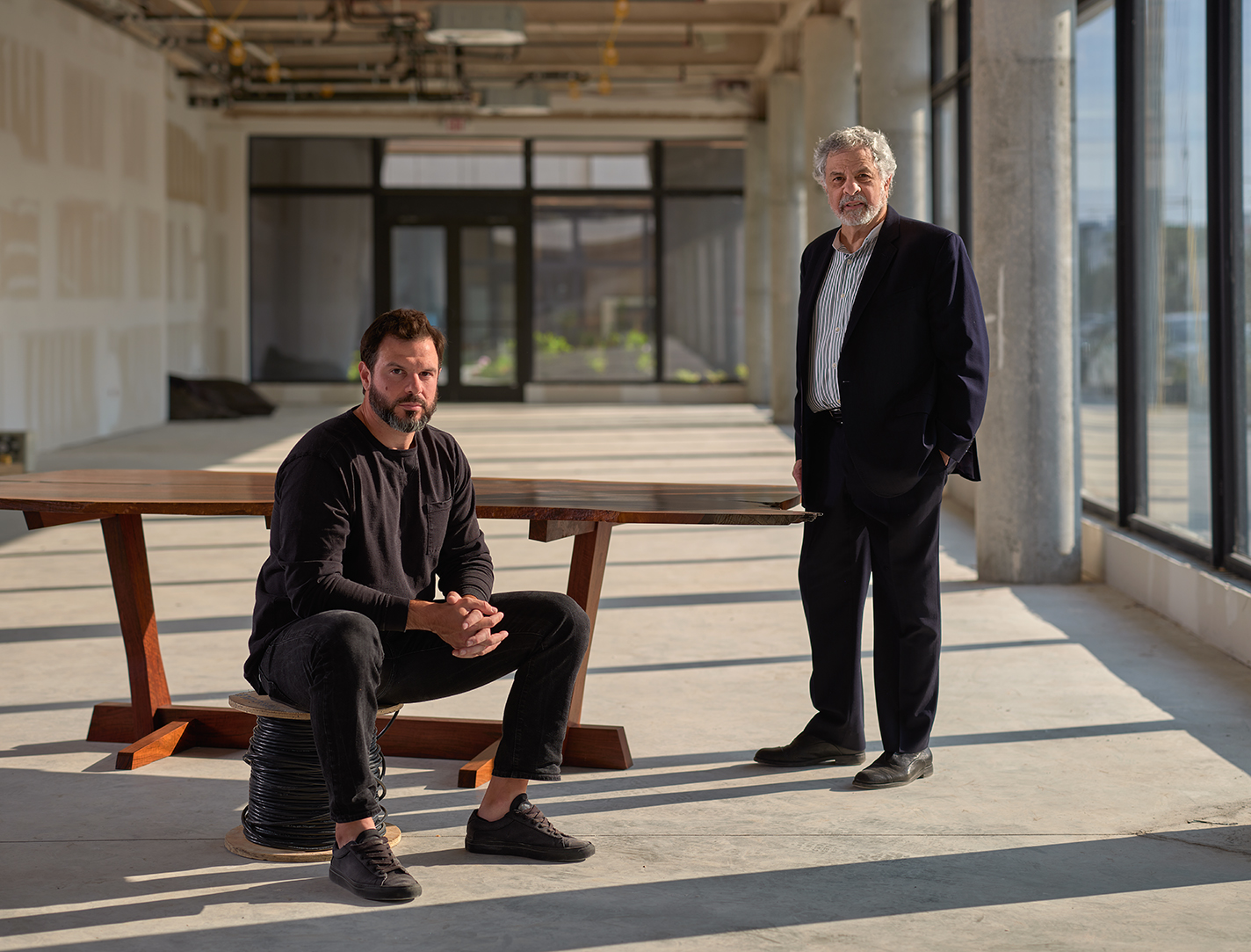 Joshua Aibel and Robert Aibel with a George Nakashima dining table.